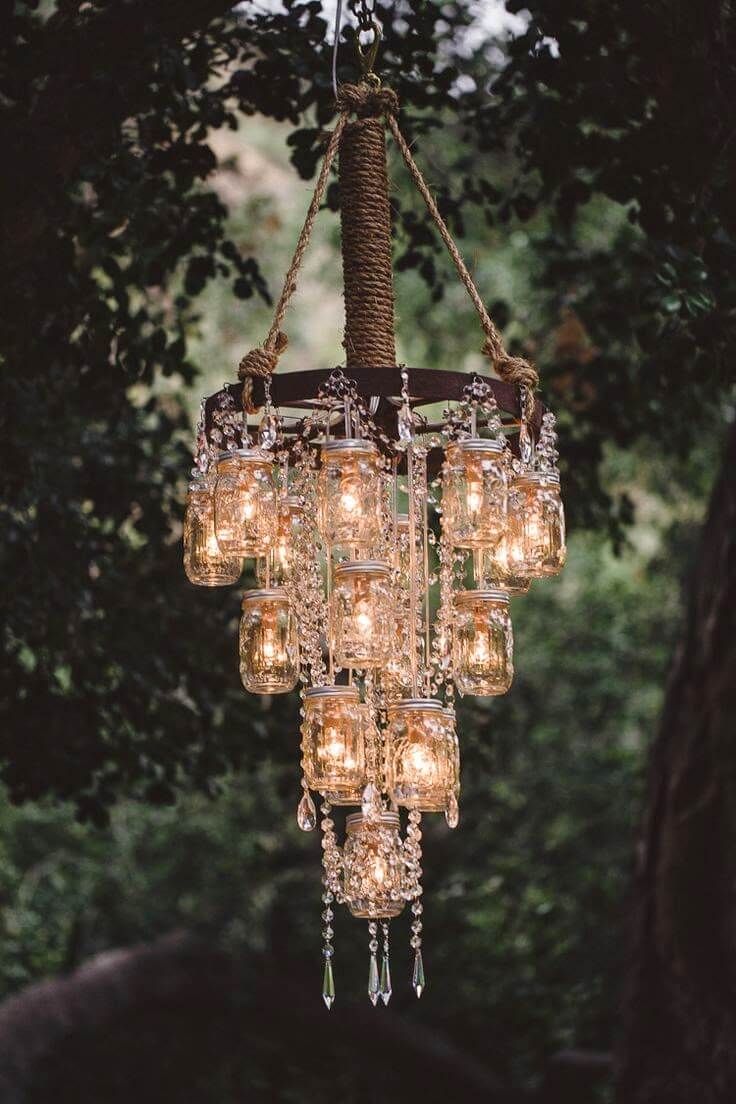 a chandelier made out of mason jars hanging from a tree