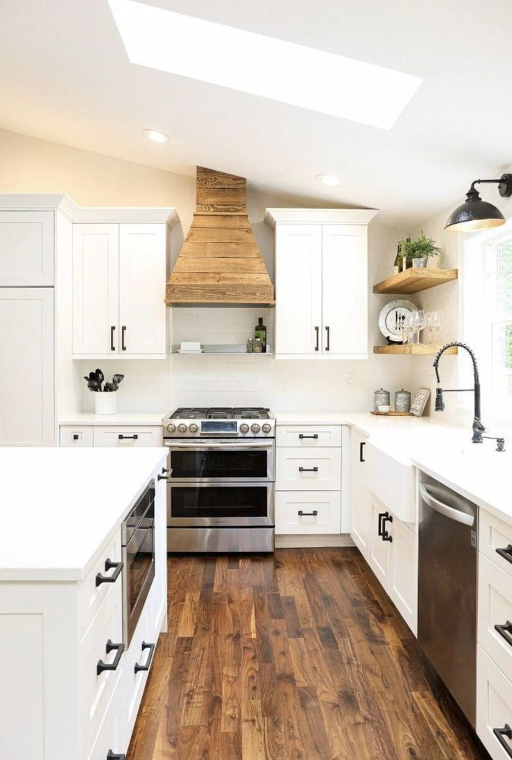 a kitchen with white cabinets and wood flooring is pictured in this image from the front view