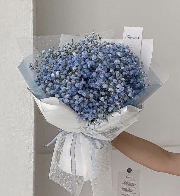 a person holding a bouquet of blue flowers