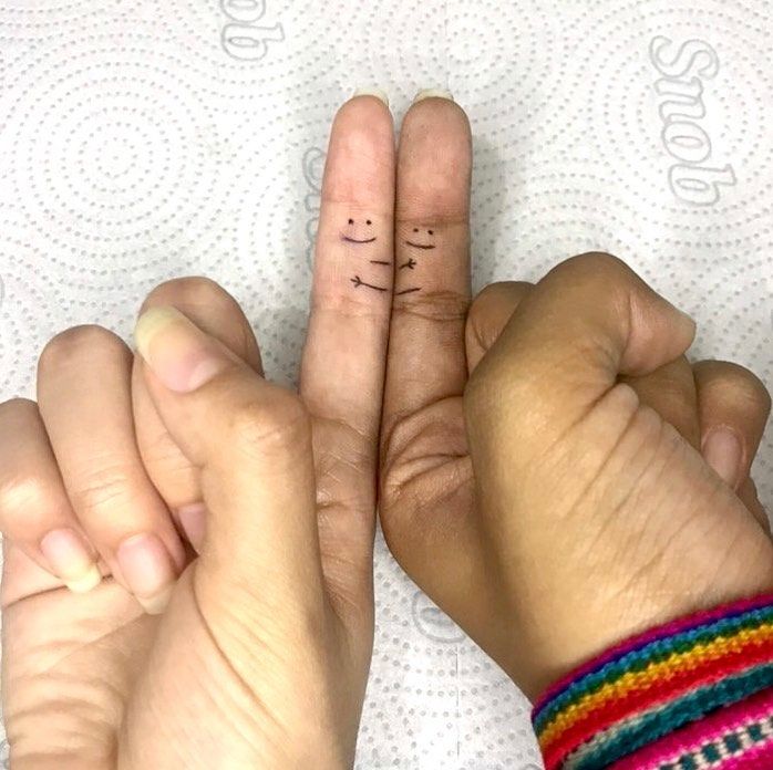 two hands with fingers that have small letters on them