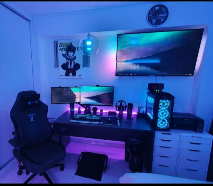 a computer desk with two monitors on it in a room filled with furniture and decor