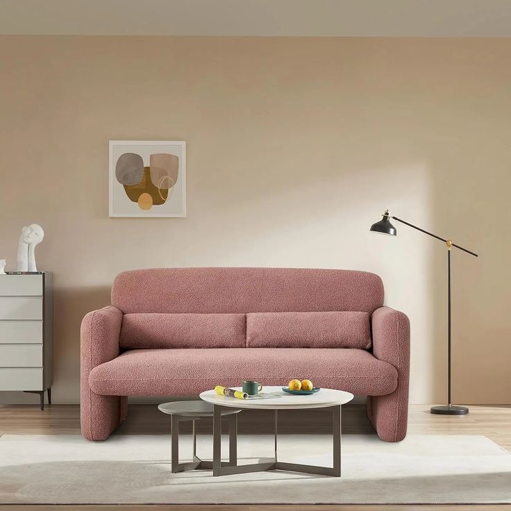 a living room with a pink couch and coffee table