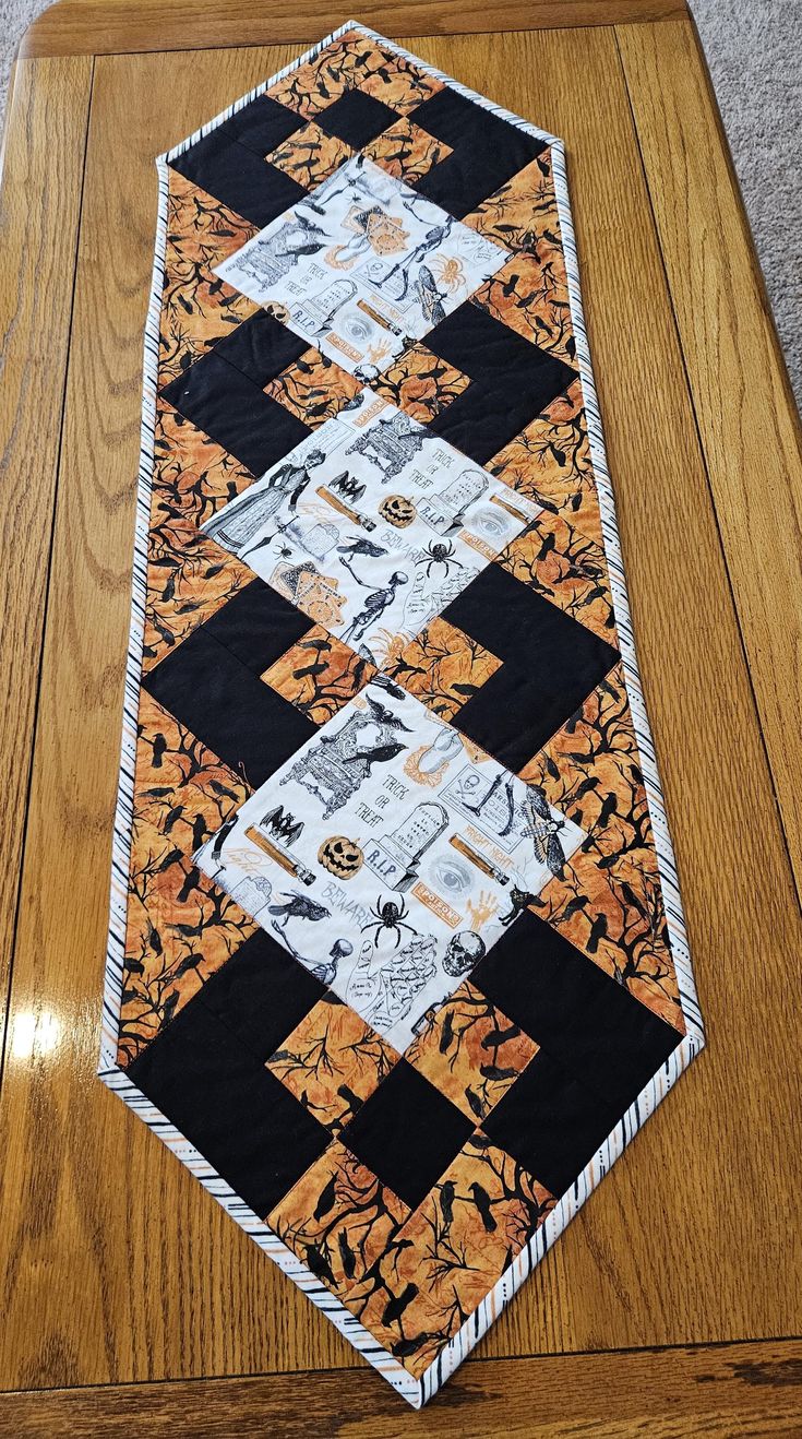 a wooden table with a black and orange quilt on it