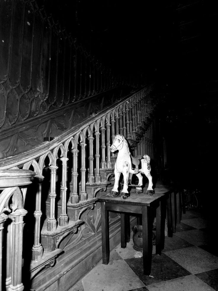 a horse statue sitting on top of a wooden table next to a bannister