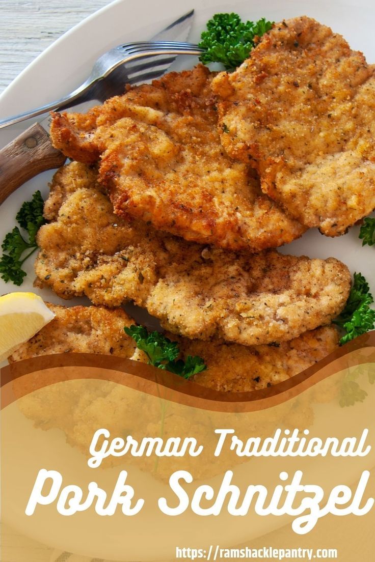 a white plate topped with fried meat and garnished with parsley next to a fork