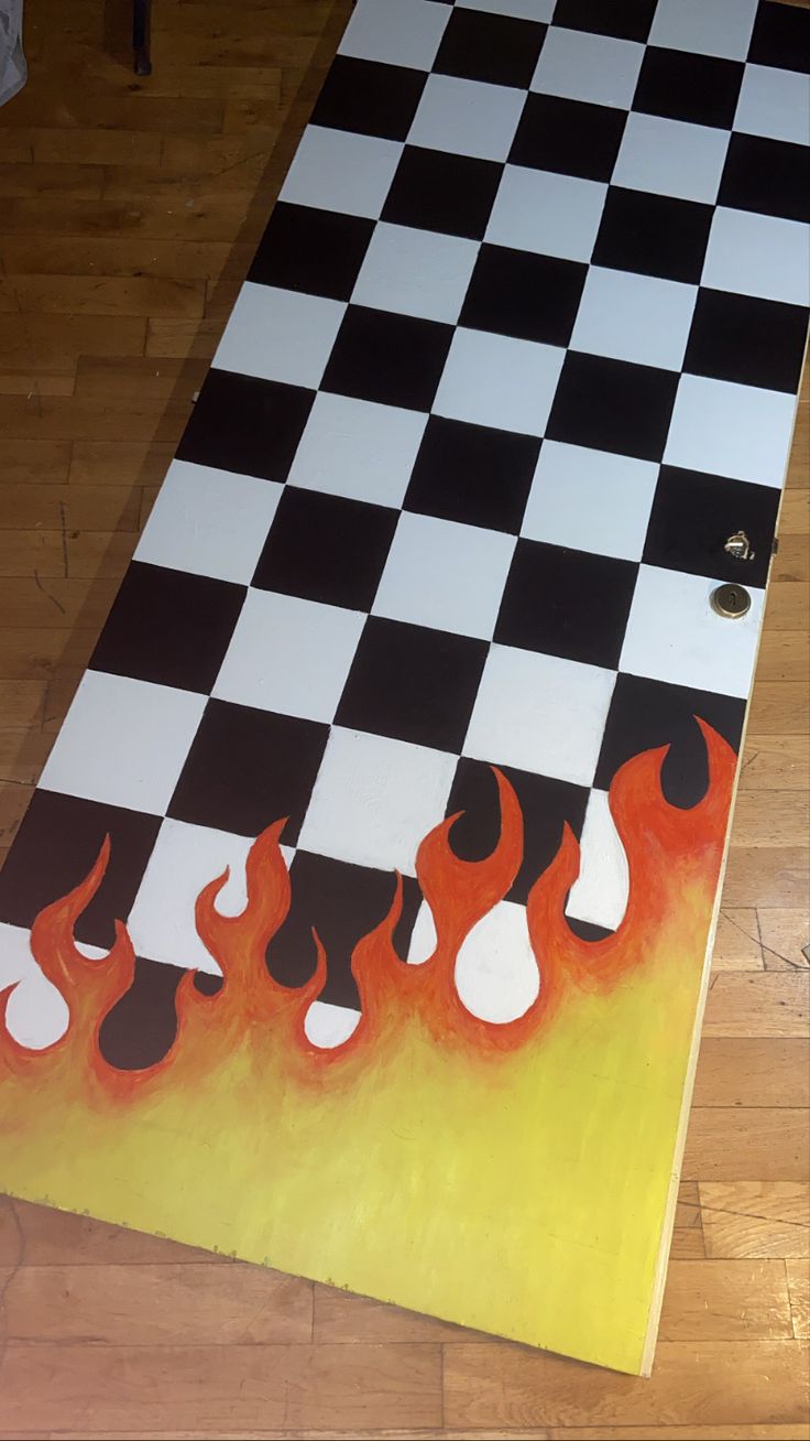 a large checkered board with flames painted on the side and black and white squares