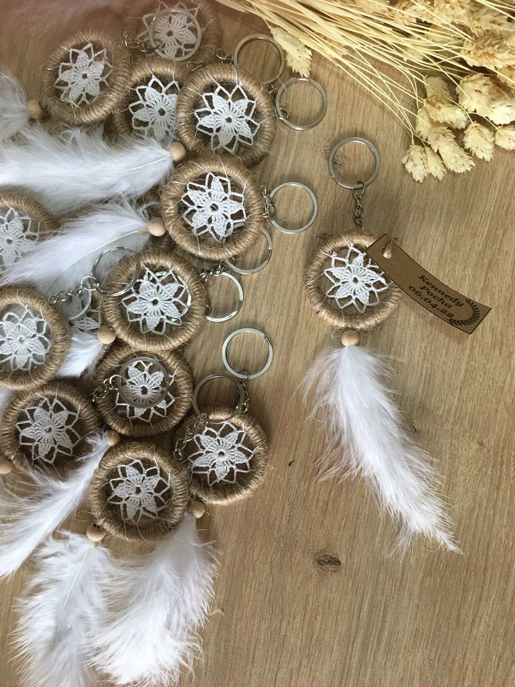 several different types of buttons and feathers on a table next to some dried wheat stalks