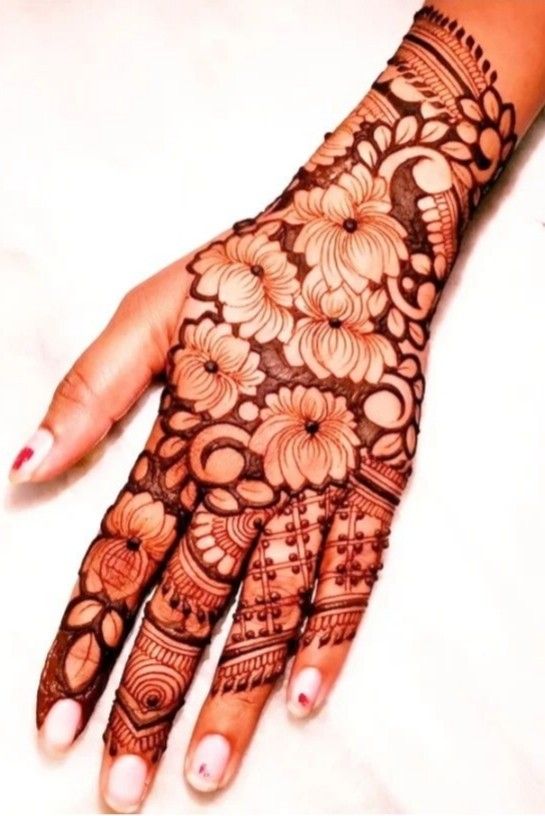 a woman's hand is decorated with hennap and flower designs on it