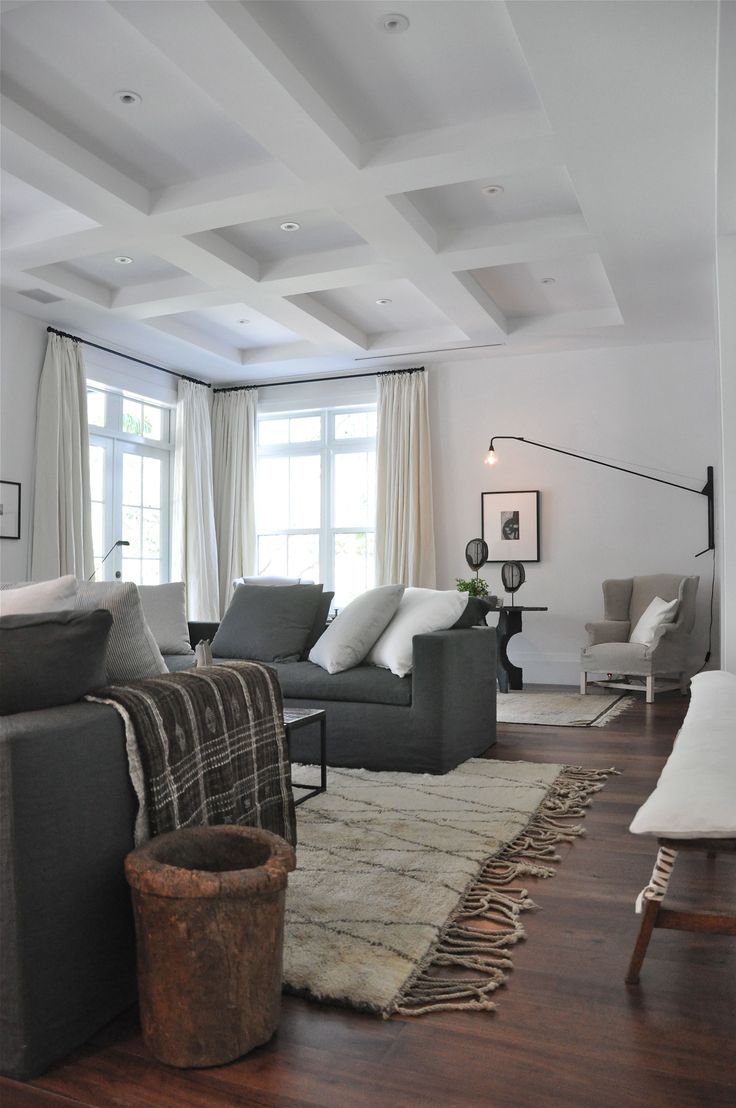 a living room filled with lots of furniture and decor on top of a hard wood floor