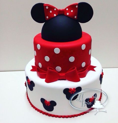 a mickey mouse cake is decorated with red and white polka dots, ears and bows