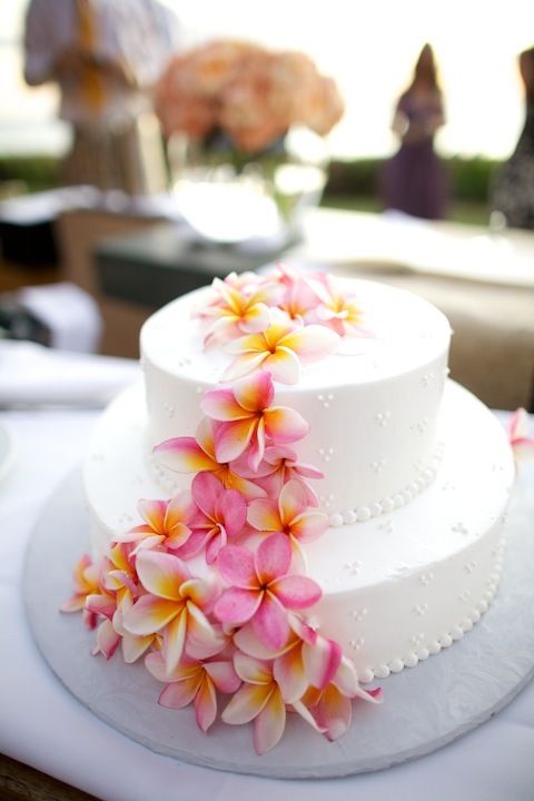 a white wedding cake with pink and yellow flowers