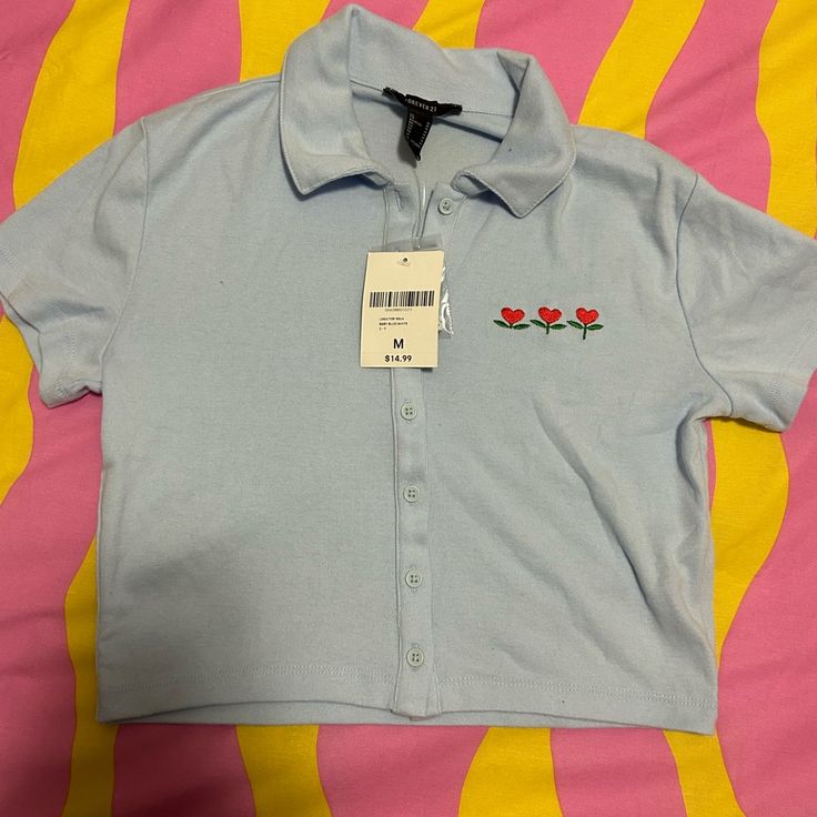 Cropped Baby Blue Polo With Red Embroidered Tulips. Total Fallout Vibes, Is It Just Me?! . Length Is More Of A Baby Tee Length Than A Crop. New With Tag. I Ship Next Day Monday-Friday! Orders Placed On Friday Will Be Shipped Out That Monday. Send Me An Offer, I Tend To Respond Right Away! Ex-Emo Here , Check Out My Closet For Killer Stuff! Emo Punk Gyaru Nu Metal Mall Goth Mcr My Chemical Romance Slipknot Korn Scene Fall Out Boy System Of A Down 90s Y2k 2000s Mcbling Trashy 60s 50s 70s Decora Ha Summer Embroidered Collared Tops, Summer Collared Tops With Floral Embroidery, Cute Button-up Summer Tops, Cute Summer Button-up Tops, Cute Blue Collared Top, Fitted Embroidered Collared Tops, Cute Blue Button-up Top, Embroidered Collared Blue Tops, Forever 21 Collared Tops For Summer