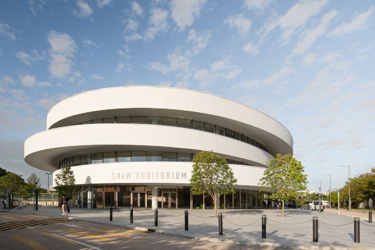 a large white circular building sitting on the side of a road