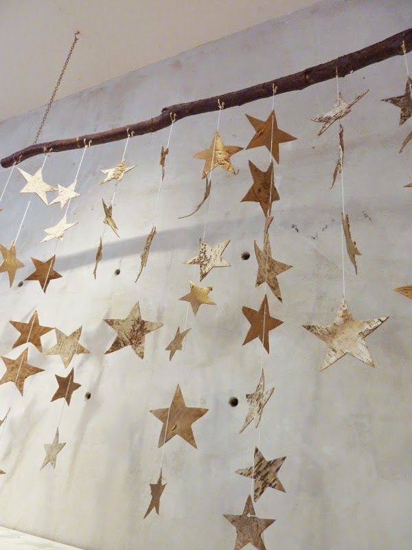 some gold stars hanging on a white wall