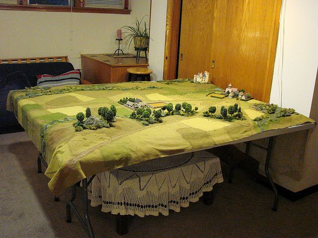 a table that has some small trees on it and is covered in yellow cloths