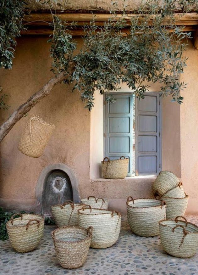 some baskets are sitting on the ground in front of a building with an open window