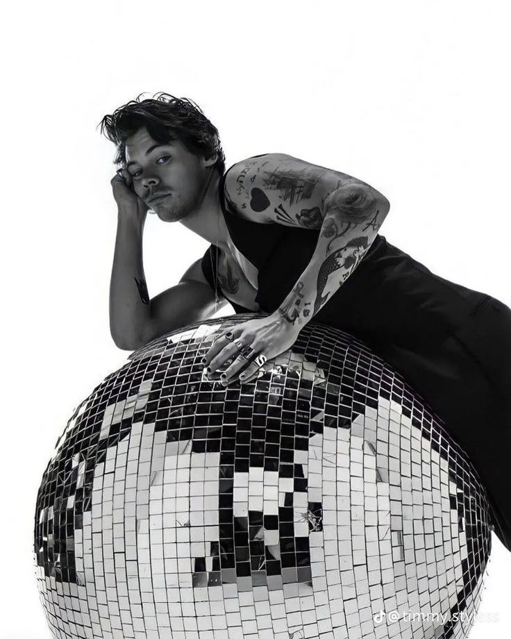 a man sitting on top of a disco ball