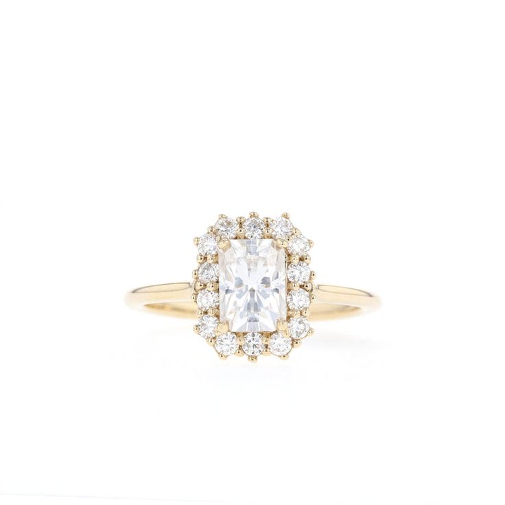 a yellow gold ring with an oval cut diamond surrounded by small round diamonds