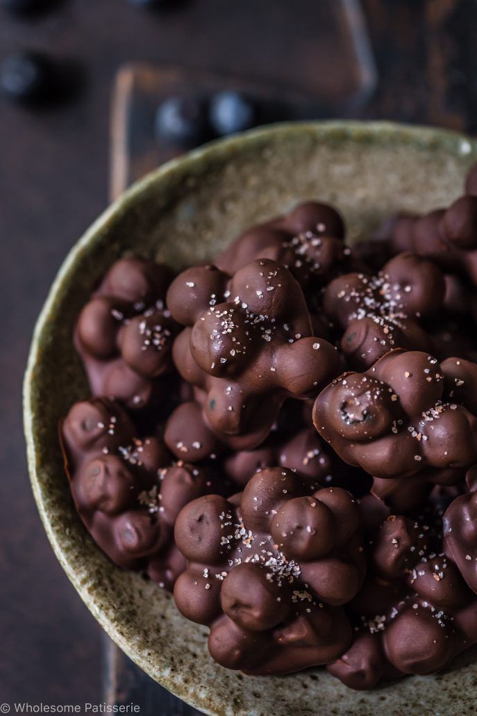 a bowl filled with chocolate covered donuts on top of a table