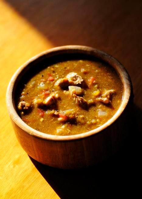 a wooden bowl filled with soup on top of a table