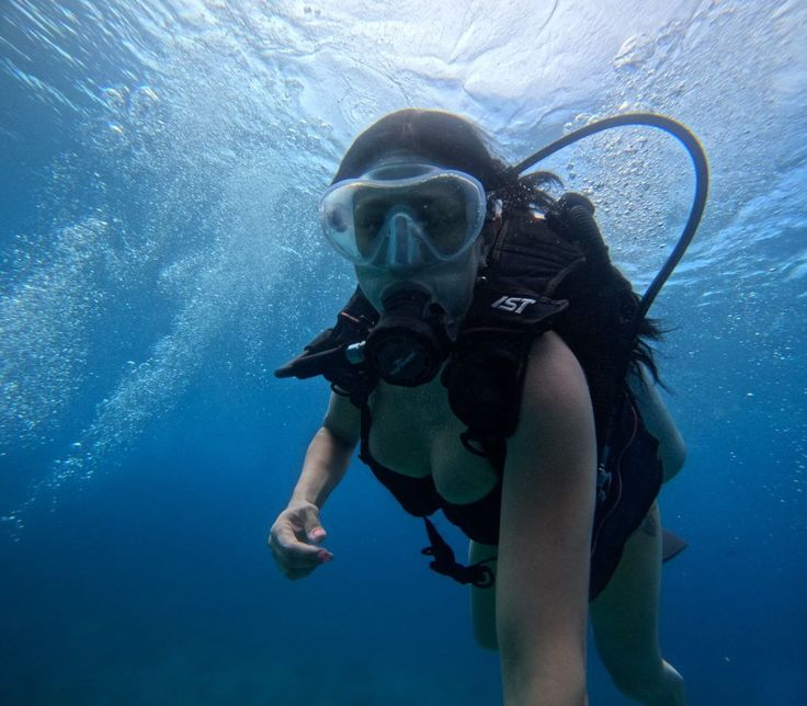 a woman wearing a diving mask and snorkels under the water's surface