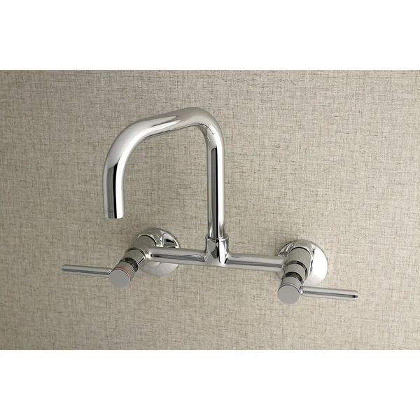 two chrome faucets mounted on the wall