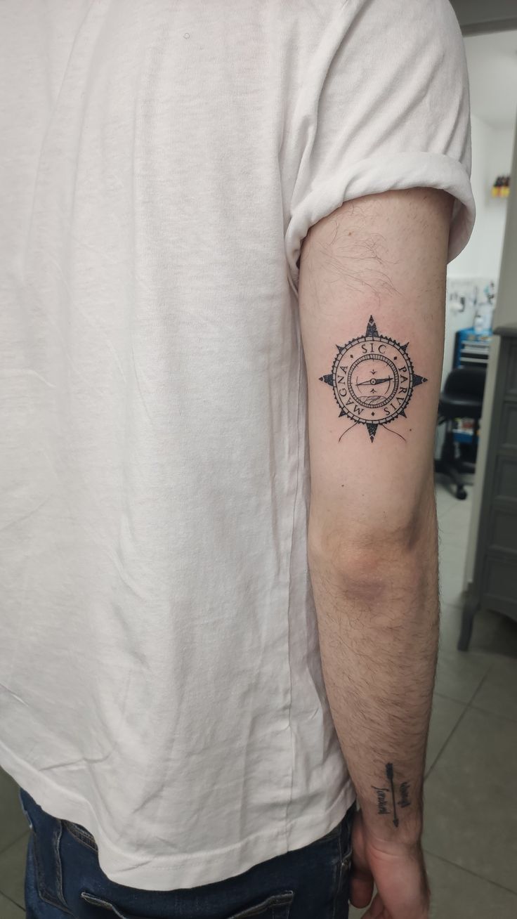 a man with a compass tattoo on his arm