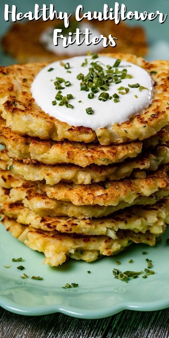 a stack of potato pancakes topped with sour cream and chives on a blue plate