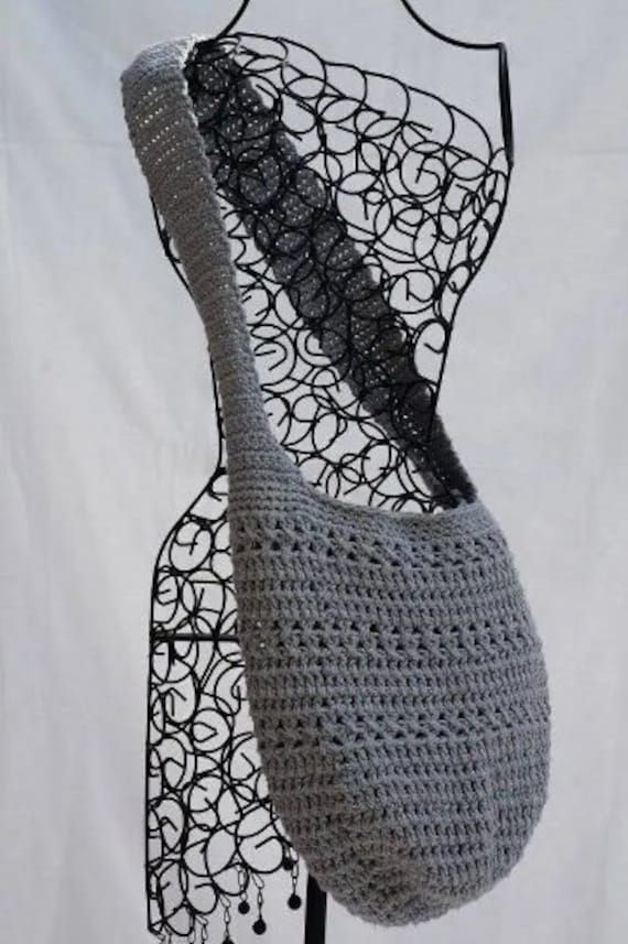 a crocheted bag hanging from a mannequin's torso