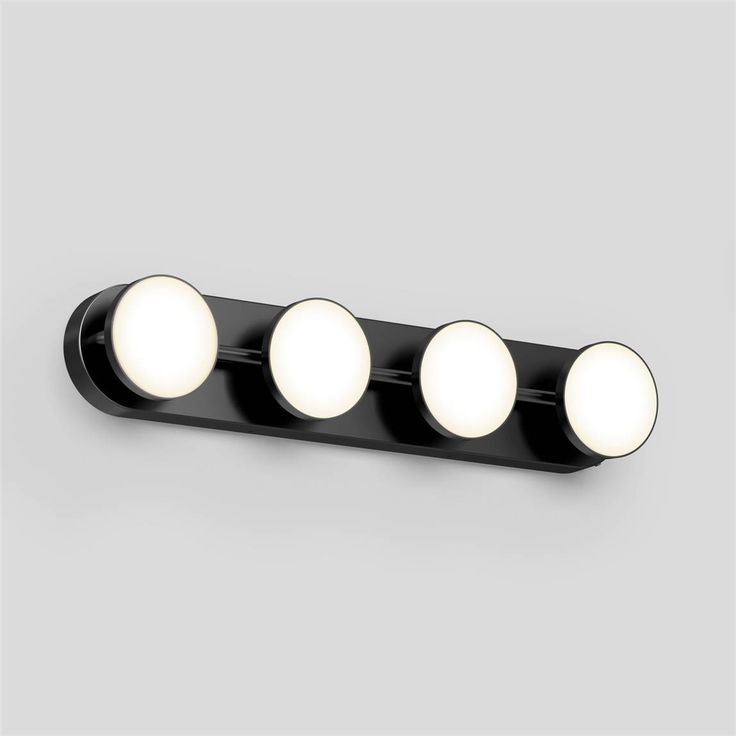 three lights that are on the side of a wall mounted fixture with four balls in it