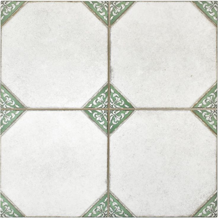 a white and green tile floor with an intricate design on the bottom half of it