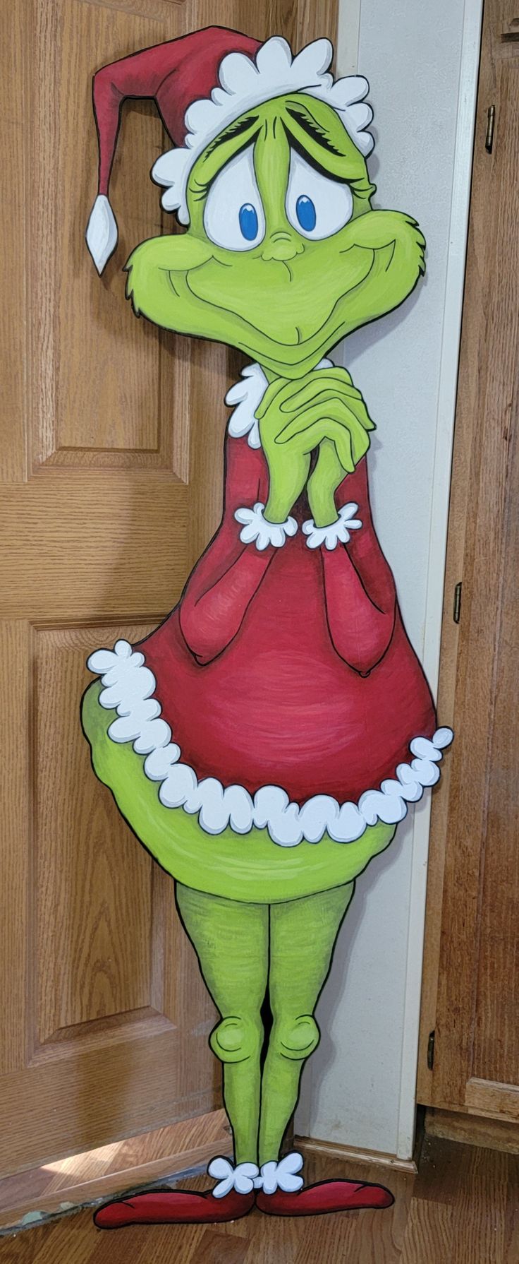 a cardboard cut out of the grinch from how the grinch stole christmas cheer