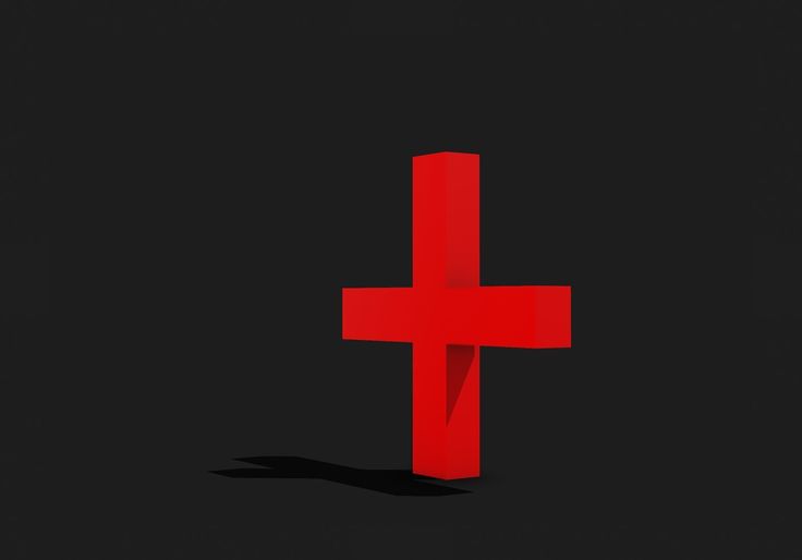 a red cross on a black background with shadow in the foreground and light at the top