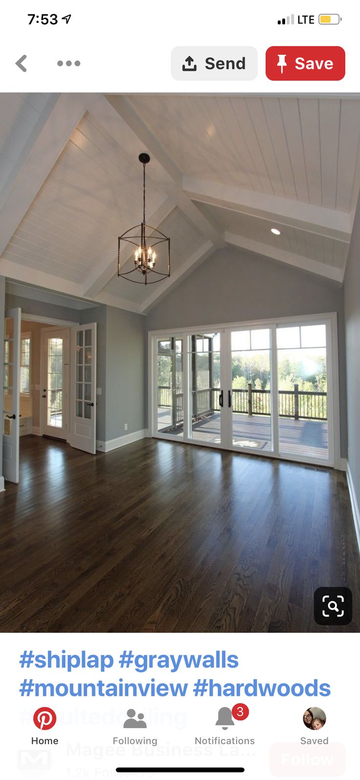 an empty living room with hard wood flooring and white painted walls, large open windows