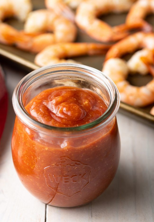 a jar filled with sauce next to some pretzels