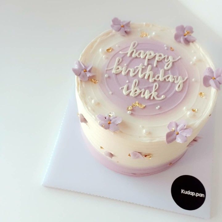 a birthday cake with white frosting and purple butterflies