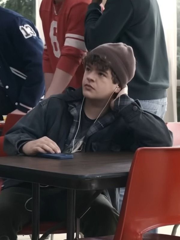 a young man sitting at a table with headphones on