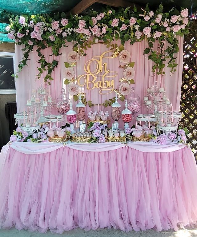 a pink and gold dessert table with flowers on it