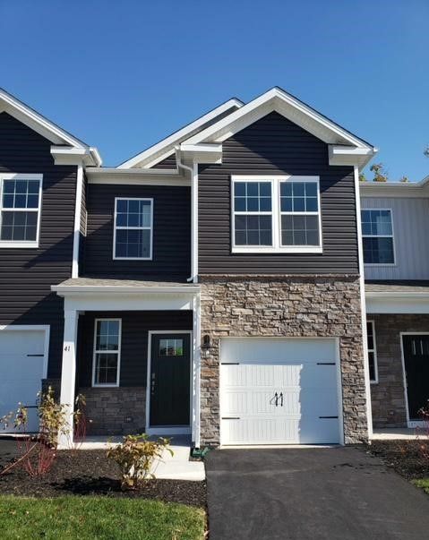 a two story house with three garages in the front and one on the side