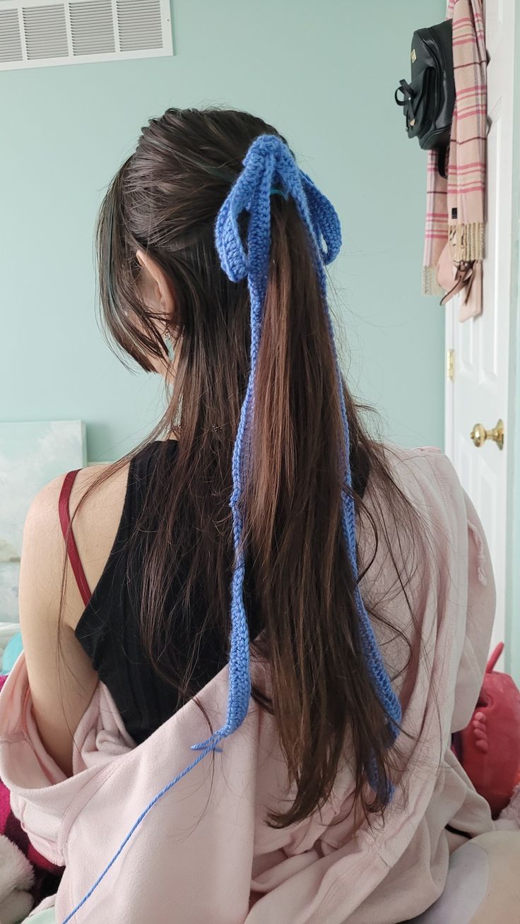 a woman sitting on top of a bed with her hair in a pony tail style ponytail