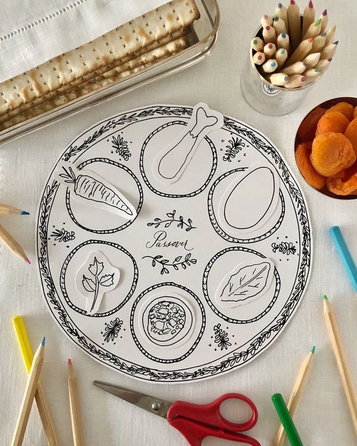 a table topped with lots of crafting supplies next to utensils and pencils