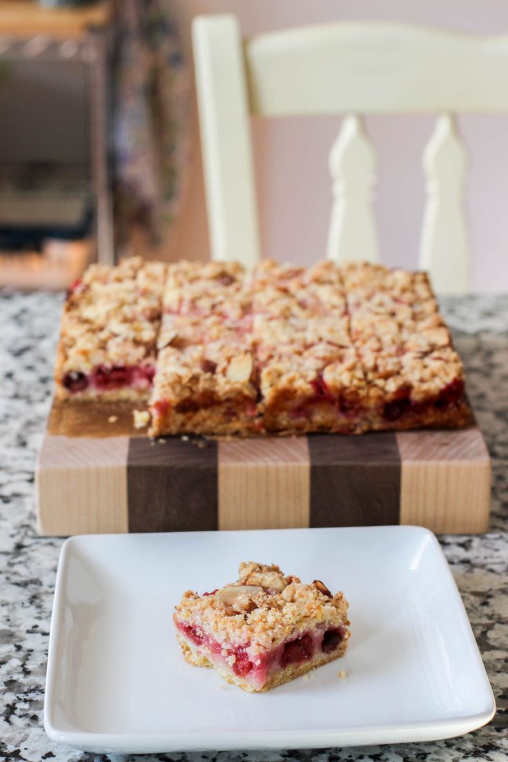 a piece of pie sitting on top of a white plate next to a wooden cutting board