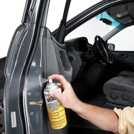 a man opening the door of a car with a can of cleaner next to it