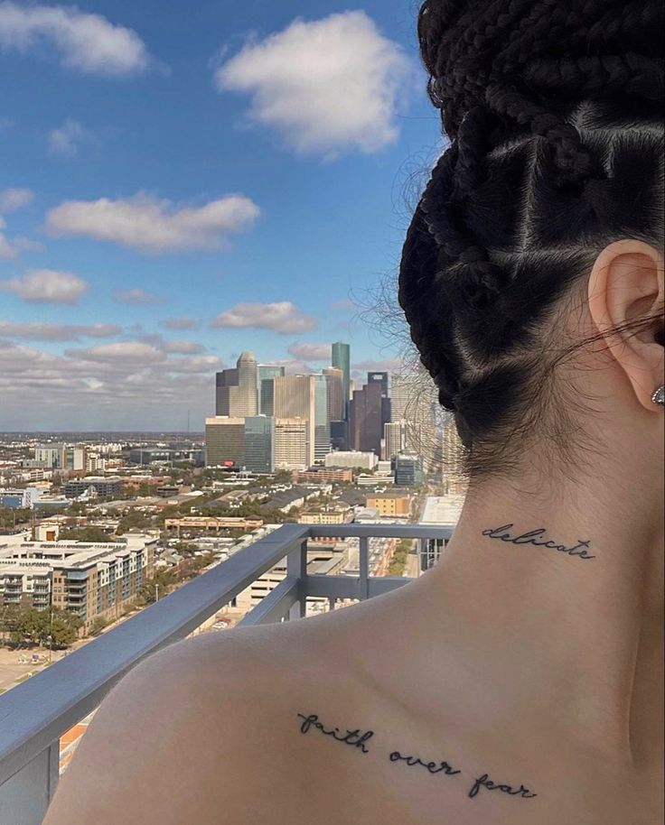 the back of a woman's head with tattoos on her neck and behind her ear