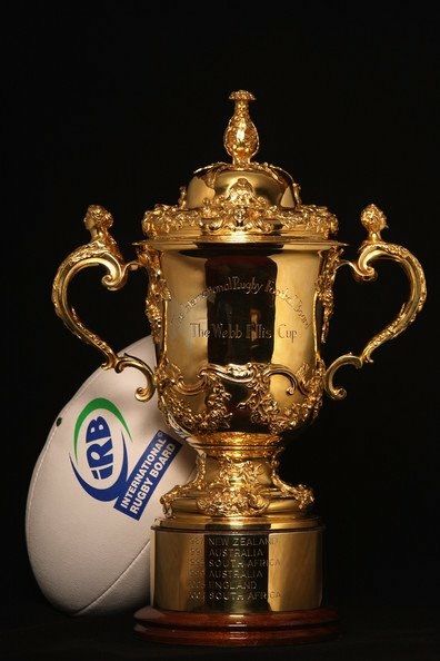 a rugby ball and trophy sitting next to each other