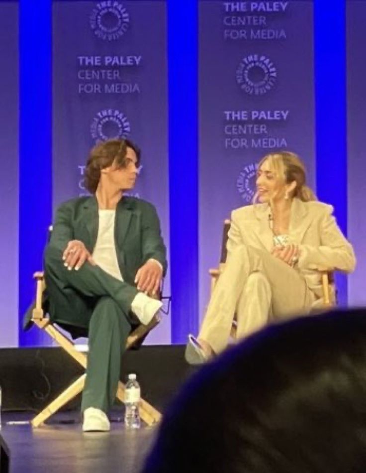 two people sitting in chairs talking to each other on stage at the paley center for media