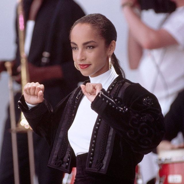 a woman wearing a black jacket and white shirt