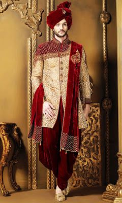 a man dressed in red and gold standing next to a golden chair with a mirror behind him