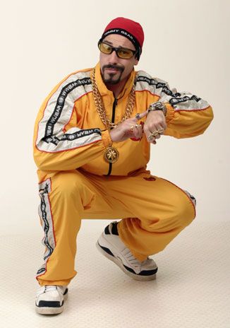 a man in an orange outfit is posing for the camera with his hands on his hips