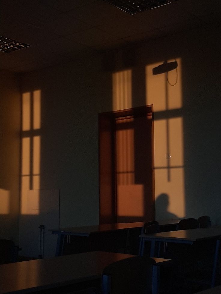 the sun is shining through two windows in an empty classroom